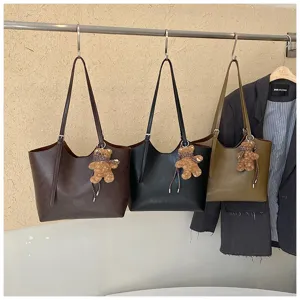 Vue détaillée du sac cabas minimaliste en cuir PU avec joli pendentif ours, idéal au quotidien.