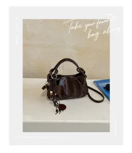 Vue détaillée du sac à main froncé marron foncé élégant avec une bandoulière chic.