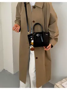 Vue détaillée du sac à bandoulière noir tendance avec boucle métallique et pendentif.