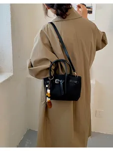 Sac à main noir élégant pour femme avec bandoulière et boucle en métal pour tous les jours.