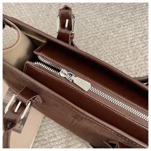 Detail view of a vintage brown women tote bag zipper and metal hardware, stylish and elegant.