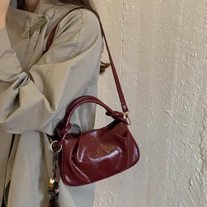 Élégant sac à main plissé pour femme, sac porté épaule en cuir verni et bandoulière tendance.