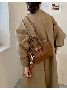 Vue détaillée du sac fourre-tout marron élégant à motif croco avec boucle et charm chic.
