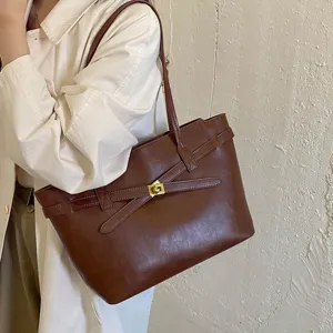 Vintage brown leather tote bag for women, elegant shoulder bag with chic belt and lock design.
