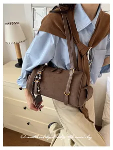 Detailansicht der braunen Wildleder-Umhängetasche im Retro-Design mit Metallbeschlägen.