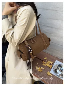 Detailansicht der braunen Damen Wildleder Boston Schultertasche mit Perlen Quaste Anhänger.