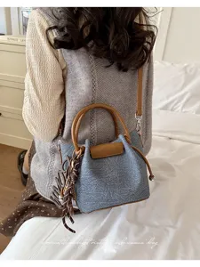 Chic vintage style women's shoulder bag with pleated denim texture and brown leather trim.