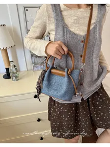 Chic denim bucket handbag for women, vintage style cross body bag with brown handles.