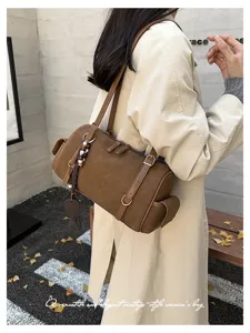 Detailansicht einer braunen Vintage-Wildleder-Boston-Umhängetasche, elegante Bowling-Optik.