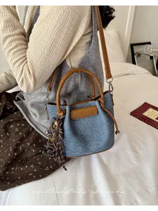 Stylish denim bucket bag for women, vintage shoulder handbag with brown leather trim.