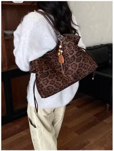 Detailed view of women leopard print shoulder tote bag, casual suede handbag style in use.