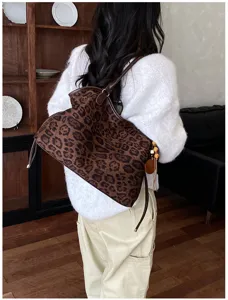 Detailed lifestyle view of retro leopard suede tote bag worn on shoulder, casual style.