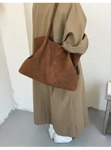 Detalle del bolso marrón de piel trenzada, con diseño clásico y una gran capacidad.