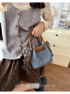 Trendy denim handbag for women, vintage style bucket bag with top handle and stylish charms.