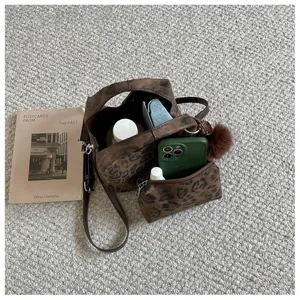 Detailansicht des Retro-Leopardenmuster-Handtaschensets mit Riemen auf strukturiertem Teppich.