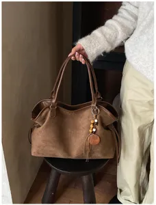 Retro brown suede tote bag detail, featuring large capacity and wooden bead pendant, casual style.