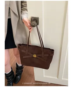 Gros plan du sac cabas rétro en daim marron, élégant sac porté épaule en scène.