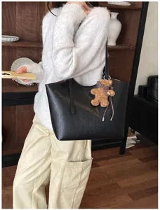Élégant sac cabas en cuir noir pour femme, sac à épaule tendance avec pendentif en forme d'ours.