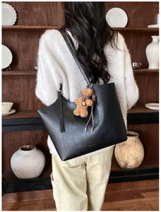 Sac cabas bandoulière noir élégant en cuir avec charmant pendentif ours pour femmes.