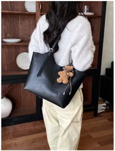 Sac cabas noir en cuir pour femme, élégant sac à épaule minimaliste avec pendentif en peluche.