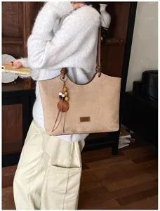 Gedetailleerd overzicht van vintage suède tote bag met houten kralen hanger en schouderriem.