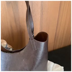 Gros plan détaillé d'un sac à épaule en cuir marron foncé, texture de qualité supérieure.