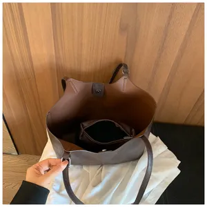 Élégant sac cabas marron en cuir avec pochette intérieure, idéal pour le travail et loisirs.