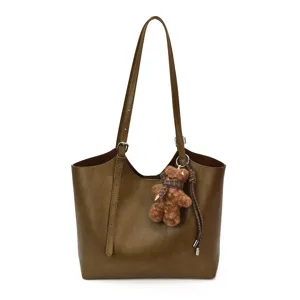 Élégant sac cabas en cuir vert pour femmes avec pendentif ours et longues bretelles.
