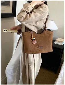 Retro bruine suède tote tas met bedel hanger, casual dagelijkse schoudertas detail.