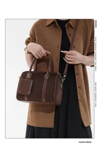 Detailansicht der braunen Vintage Wildleder Boston Tasche mit Metallbeschlägen.