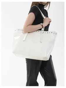 Detailansicht der stylischen weißen, glänzenden Schulter-Tote-Tasche mit Metalldetails.