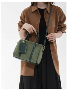 Vintage grüne Wildleder Boston Handtasche mit dunkelgrüner Lederbesatz, Griffen und Umhänageriemen.