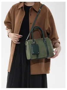 Grüne Wildleder Boston Schultertasche Detailansicht mit Retro Design, Griffen und Elementen.