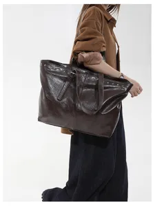Detaillierte Ansicht der braunen Shopper Tasche mit Metallösen und praktischen Tragegriffen.