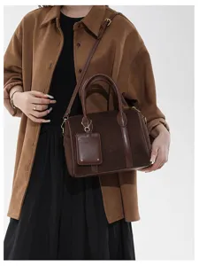 Detailansicht der braunen Retro-Wildleder-Boston-Handtasche mit feiner Textur und Beschlägen.