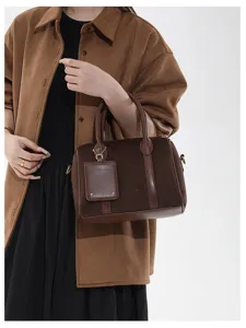 Detailaufnahme der braunen Veloursleder Boston Handtasche mit edler Textur und tollem Griff.