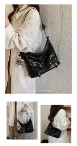 Black patent leather messenger bag with cute doll pendant, versatile retro shoulder crossbody bag for women.