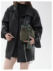 Detail view of retro matte bucket bag with tassel drawstring, stylish crossbody and shoulder wear.