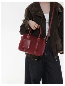 Detailansicht der dunkelroten Wildleder-Handtasche, mit hochwertiger Ledertextur und feinen Metallen.