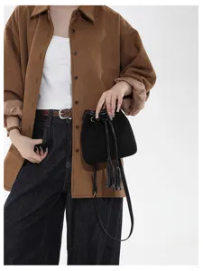 Women retro suede bucket bag with tassels, fashion autumn winter crossbody shoulder bag detail.