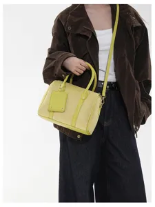 Nahaufnahme der stilvollen gelben Wildleder Boston Handtasche mit feiner Textur und Henkeln.