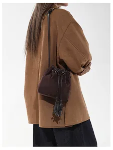 Women suede bucket bag with stylish tassel decor, casual brown crossbody shoulder purse detail.