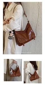 Detailed view of the stylish retro brown messenger bag featuring a cute doll pendant charm.