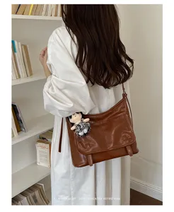 Stylish retro brown leather messenger bag for women, versatile crossbody shoulder bag.