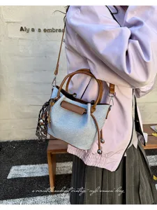 Detailed view of the stylish retro bucket bag featuring contrast brown handles and chic charms.