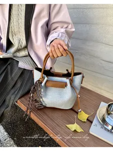 Stylish women denim handbag shoulder crossbody bag with elegant brown leather trim and charm.