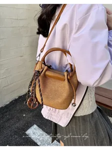 Detailed shot of the vintage canvas bucket bag showing textured fabric and stylish charms.