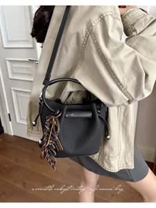 Detailed view of stylish black bucket handbag with chic charm, perfect autumn daily wear.