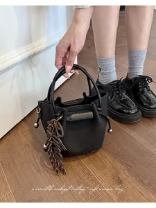 Women's black PU leather bucket bag stylish vintage handbag with chic strap and cute charms.