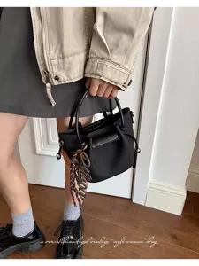 Chic black bucket bag for women, stylish vintage shoulder handbag with trendy strap and charm.